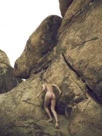 Thumbnail Naked girl climbing up rock in the desert by Stefan Rappo