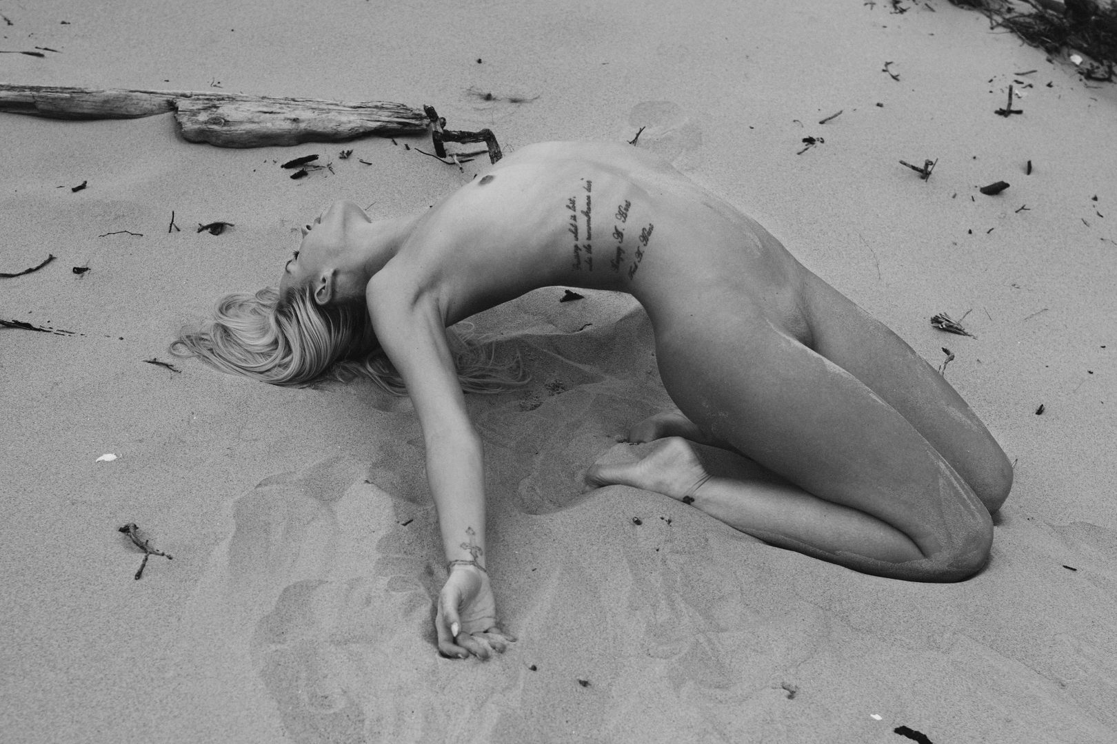 Naked girl lying on beach by Stefan Rappo