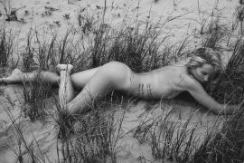 Thumbnail Naked girl lying on the beach between grass by Stefan Rappo