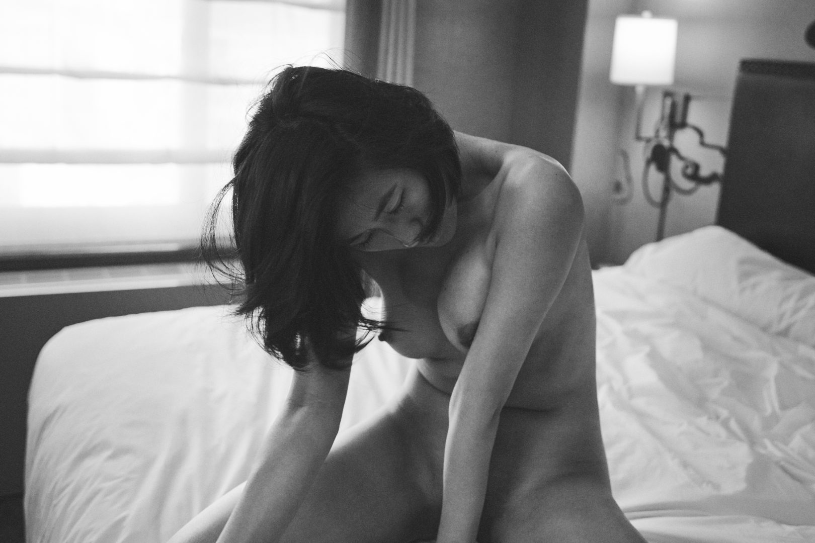 girl sitting on bed in hotel room