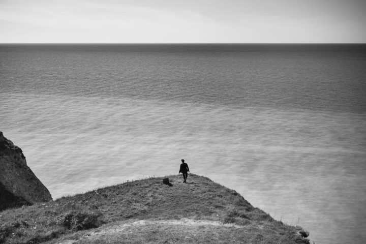 man standing on cliff by Stefan Rappo