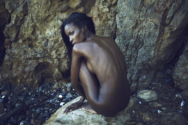 Thumbnail Naked girl on beach in front of big rock by Stefan Rappo