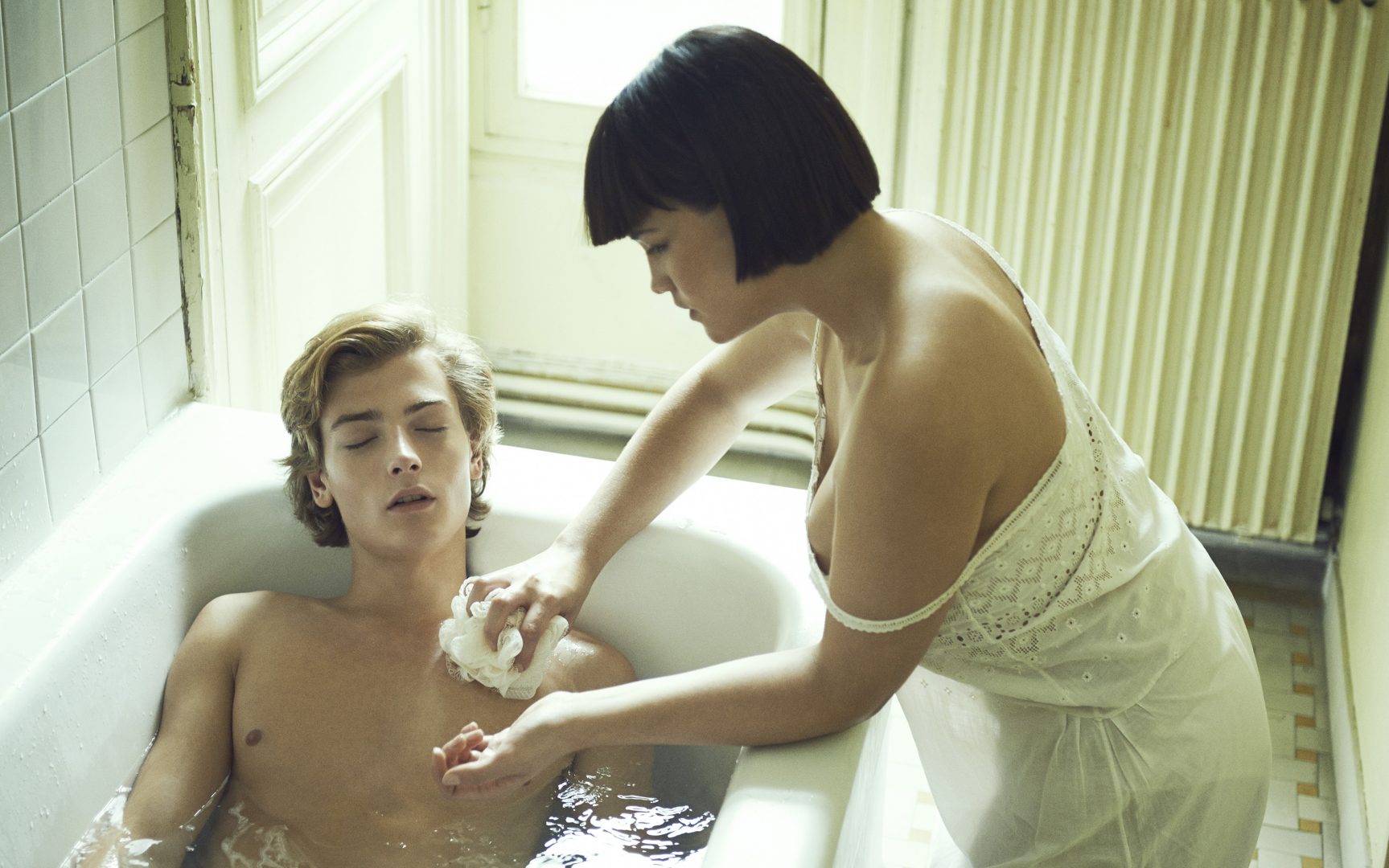 Girl giving boy a bath by Stefan Rappo
