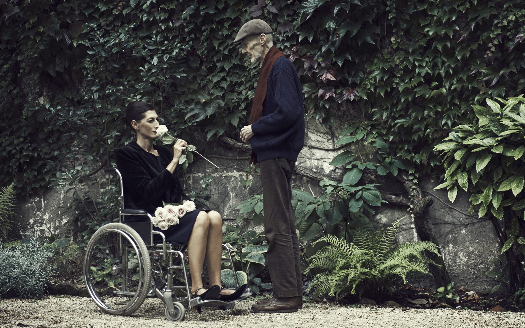 man giving a rose to women in wheelchair by Stefan Rappo