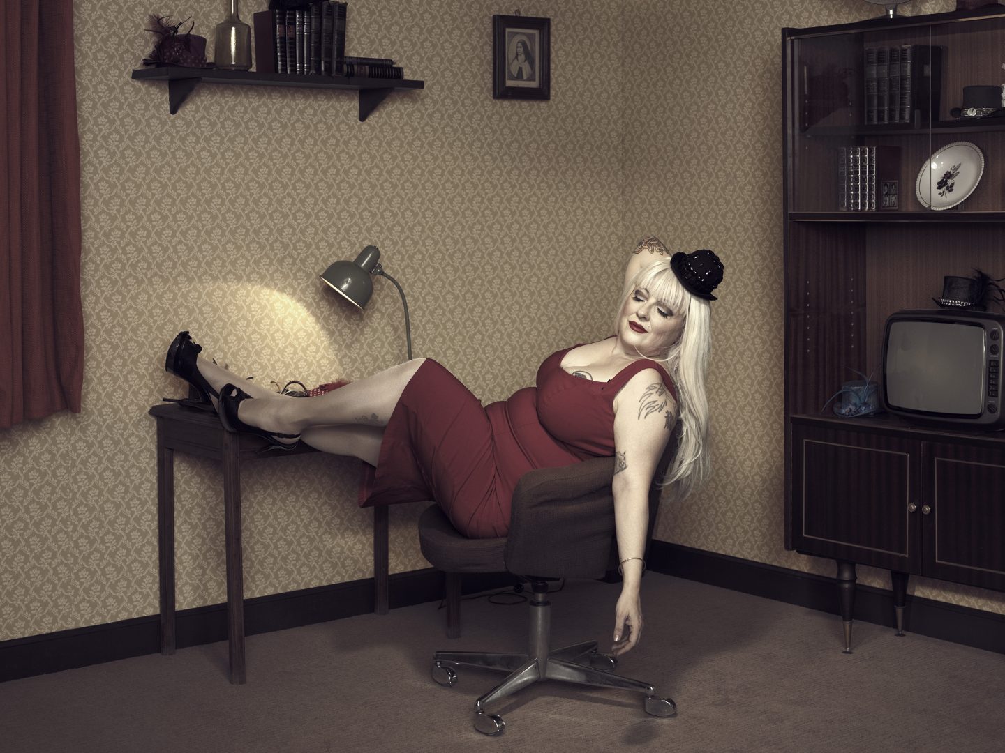 Woman in red dress sitting on chair in room 42 by Stefan Rappo