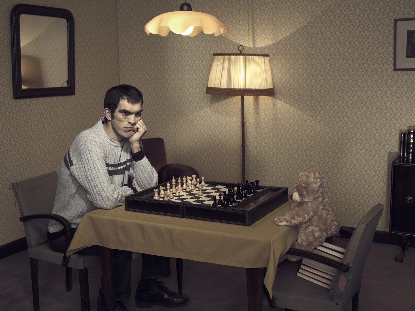 Man playing chess with teddy in room 42 by Stefan Rappo
