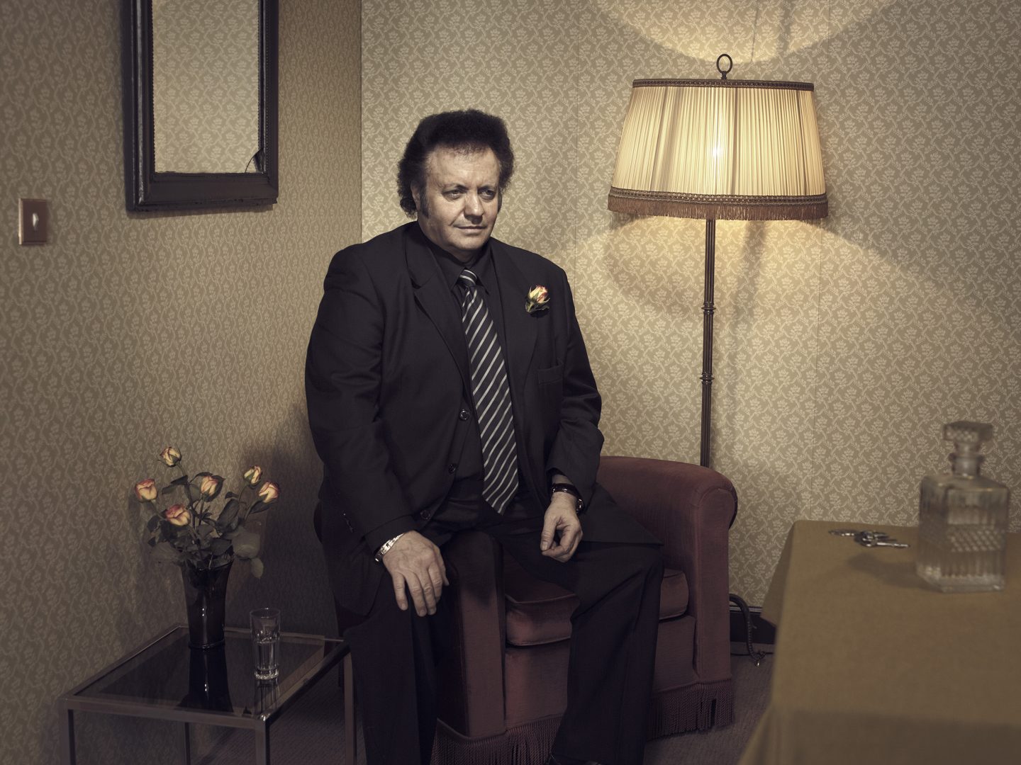 Man sitting on armchair in room 42 by Stefan Rappo