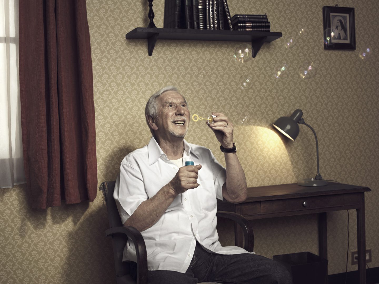 Old man making soap bubbles in room 42 by Stefan Rappo