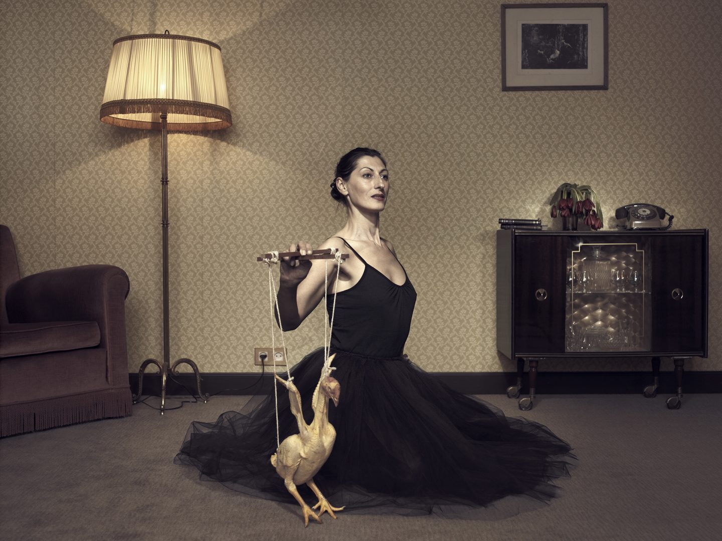 Woman playing with chicken in room 42 by Stefan Rappo